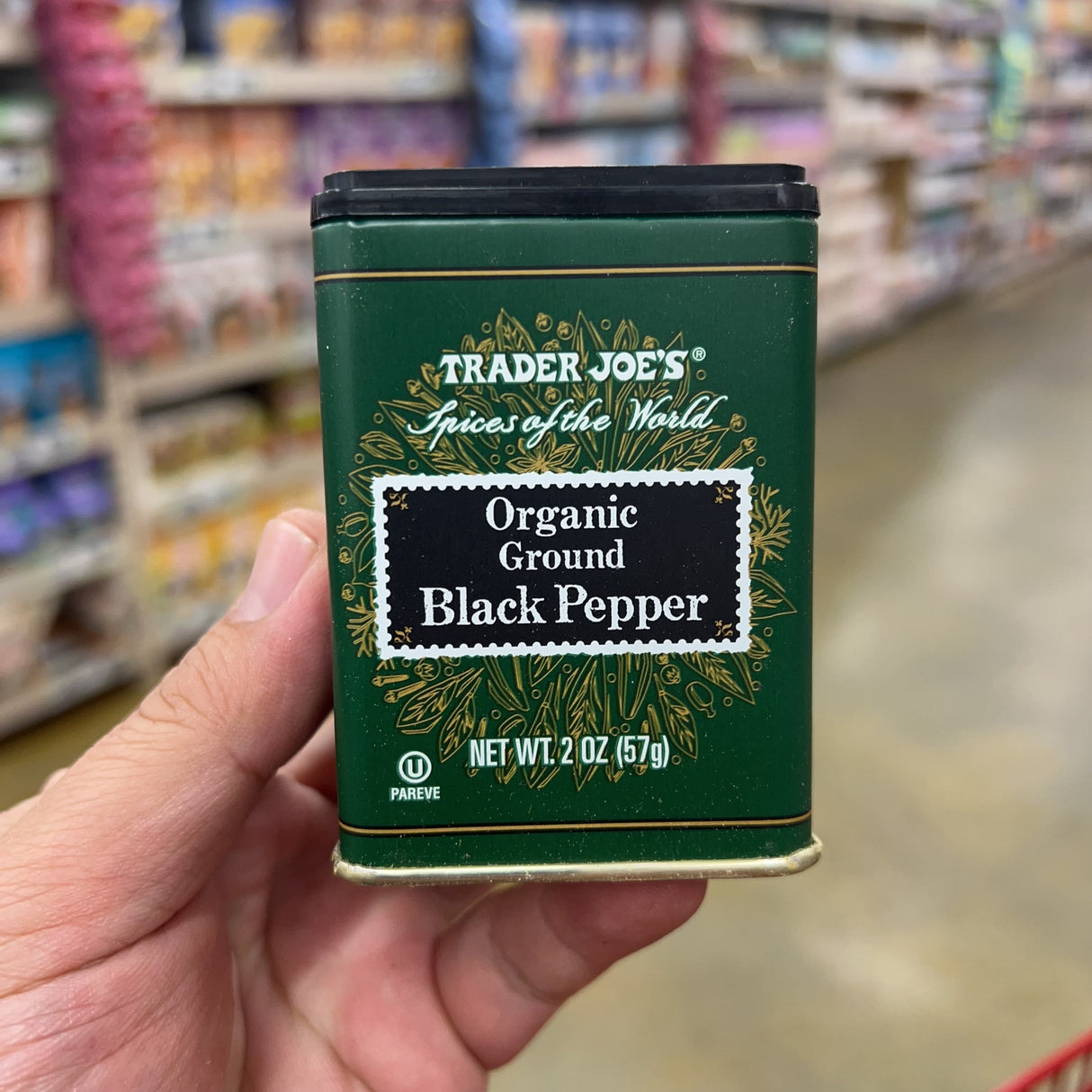 Trader Joe's Spices of the World Organic Ground Black Pepper 2 oz dark green metal tin front, U Pareve, Net Wt. 2 oz 57g, gold botanical illustration, black flip-top lid