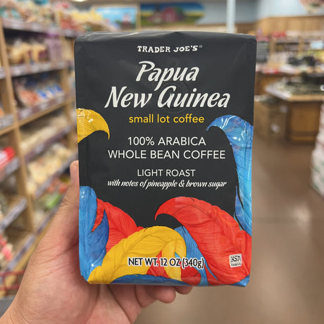 Trader Joe's Papua New Guinea Small Lot Coffee — second front view showing full bag design with colorful feathers (blue, red, yellow) and Trader Joe's Papua New Guinea small lot coffee branding, net wt 12 oz (340g)