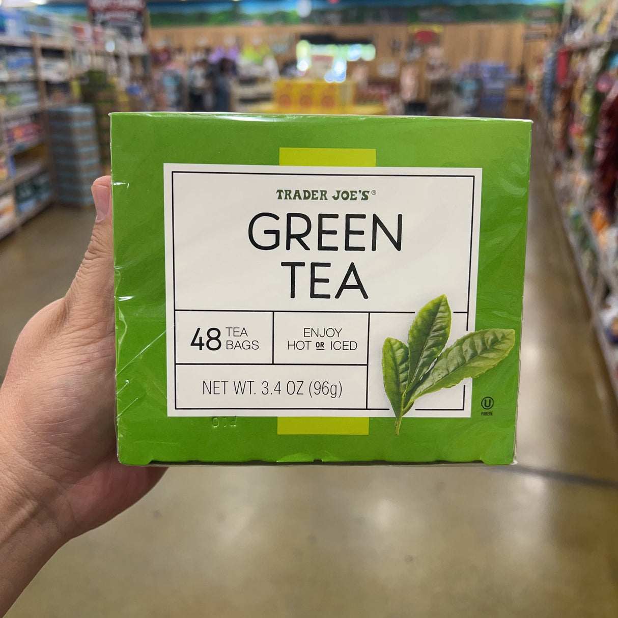 Trader Joe's Green Tea 48 bags 3.4 oz green box front second angle held in hand in store aisle