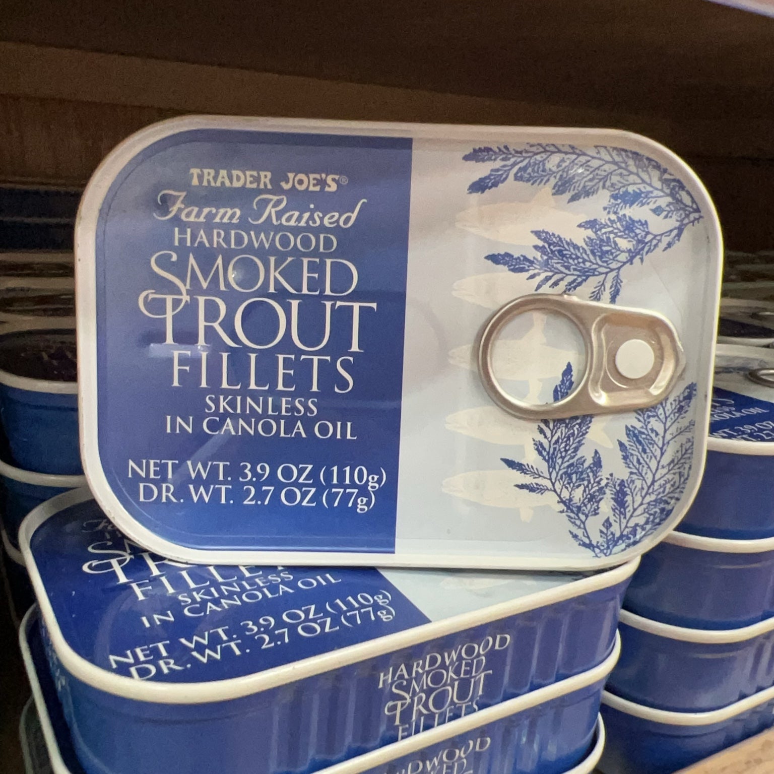Trader Joe's Hardwood Smoked Trout Fillets tins displayed on store shelf